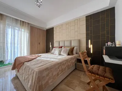 a bedroom with a large bed and a chair at Charmant Appart Moderne au Cœur de Rabat avec Fibre in Rabat