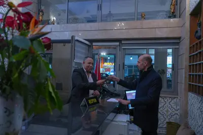 two men in suits standing in front of a table with a camera at Appart-Hôtel BEL ANFA in Casablanca