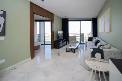 a living room with a couch and chairs and windows at Luxueux Appartement 2 Chambres, Vue Casa Port in Casablanca