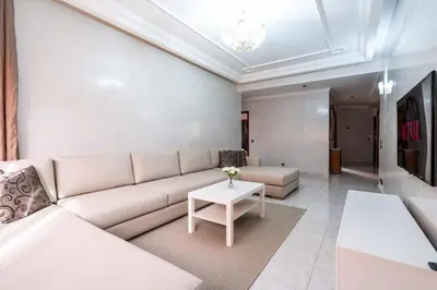 a living room with a white couch and a table at Appartement Cosy à Maarif, à Côté du McDonald's in Casablanca