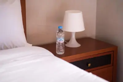 a bottle of water sitting on a table next to a bed at Appartement Cosy à Maarif, à Côté du McDonald's in Casablanca