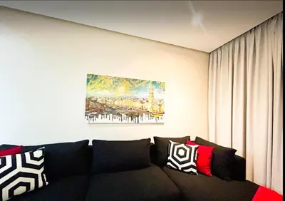 a couch in a living room with a painting on the wall at Beach Front Apartement With Pool in Casablanca