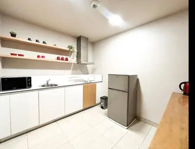 a kitchen with white cabinets and a stainless steel refrigerator at Beach Front Apartement With Pool in Casablanca