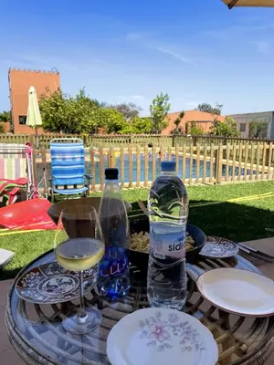 a table with two glasses and a bottle of water at premium farmhouse with pool Rabat in Rabat