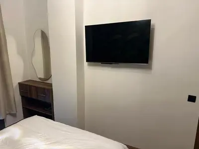 a flat screen tv hanging on a white wall at Cozy appartement luxueux in Mohammedia