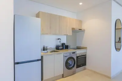 a kitchen with a sink and a washing machine at Résidence Tour 33 - CFC district in Casablanca