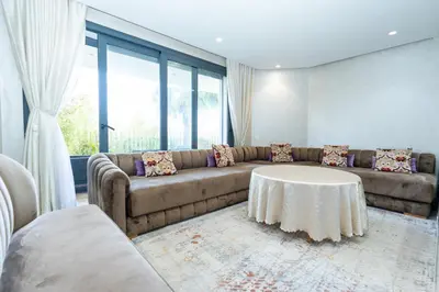 a living room with a couch and a table at Appartement luxueux avec jardin in Rabat