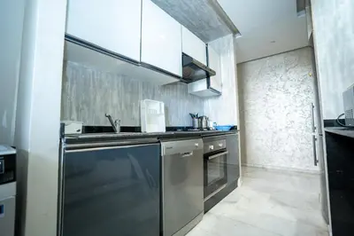 a kitchen with a sink and a dishwasher at Appartement luxueux avec jardin in Rabat