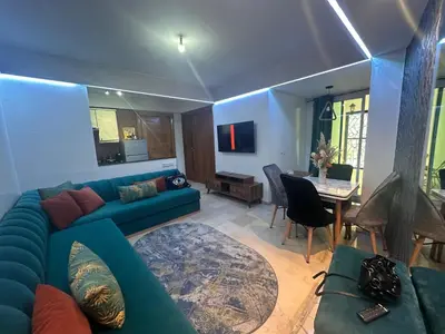 a living room with a blue couch and a table at Studio au cœur du centre ville de Casablanca in Casablanca