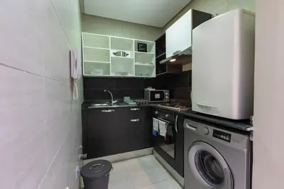 a small kitchen with a washing machine and a washer at Modern & Chic APT Prestigia by MERAT HOME in Rabat