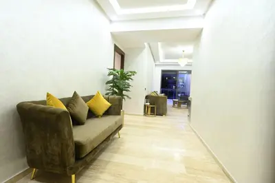 a living room with a couch with yellow pillows at Apartment in Dar Bouazza with Pool, Gym & Kids Playground in Dar Bouazza
