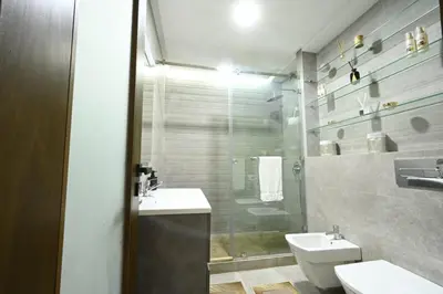 a bathroom with a sink and a toilet and a shower at Apartment in Dar Bouazza with Pool, Gym & Kids Playground in Dar Bouazza