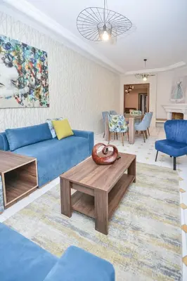 a living room with a blue couch and a table at Cozy 2 BR Gauthier Oasis in Casablanca