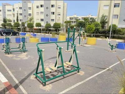 an empty playground in a parking lot with blue chairs at La perle in Pont Blondin