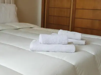 two white towels sitting on top of a bed at La perle in Pont Blondin