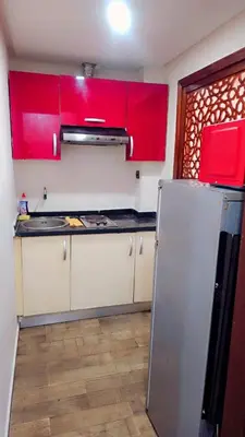 a kitchen with red cabinets and a stainless steel refrigerator at Mi mini estudio 3 in Rabat