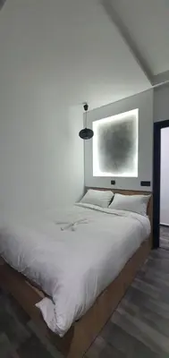 a bedroom with a large white bed with a window at Cozy Apartement B-House Airport in Berrechid