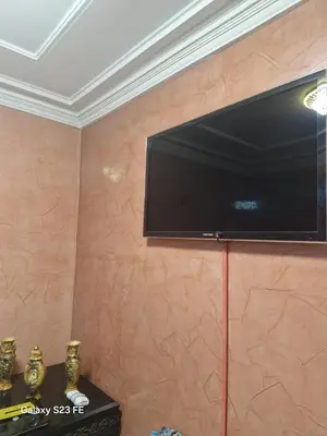 a flat screen tv hanging on a wall at Baghdad 4 in Aïn Harrouda