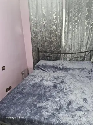 a bedroom with a bed and a window with a curtain at Baghdad 4 in Aïn Harrouda