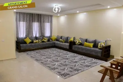 a living room with a couch with yellow pillows at Bel Appartement à louer à Mansouria in Pont Blondin