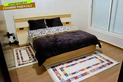 a bedroom with a bed and a rug at Bel Appartement à louer à Mansouria in Pont Blondin