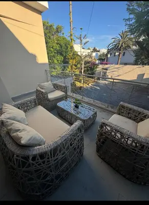 a patio with couches and a table on a balcony at Spacious Apartment Entire Villa Floor 2 Bedrooms in Rabat