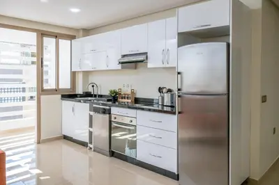 a kitchen with white cabinets and a stainless steel refrigerator at Very Charming Apartments with balcony, Haut Agdal in Rabat
