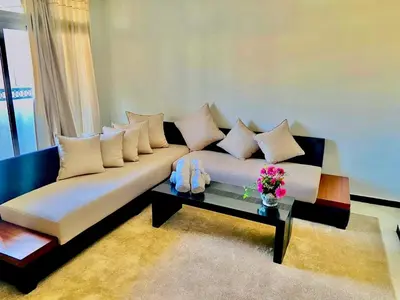 a living room with a couch with pillows and a table at Oscar Hotel in Rabat