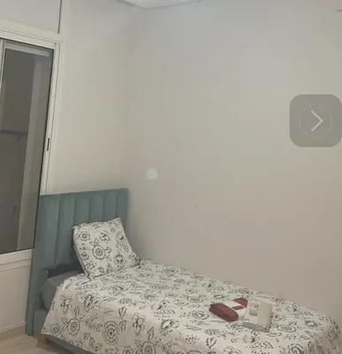 a bedroom with a bed with a pillow and two books at Appartement haut standing Mohammedia Parc in Mohammedia