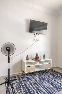 a room with a tv and a table with a lamp at Cozy studio moderne Agdal in Rabat