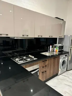 a kitchen with white cabinets and a stove top oven at Emma's Duplex in Casablanca
