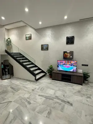 a living room with a staircase and a flat screen tv at Emma's Duplex in Casablanca