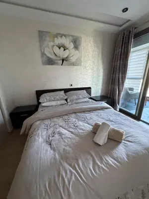 a bedroom with a white bed with two towels on it at Appartement 3 chambres moderne a californie Casablanca in Casablanca