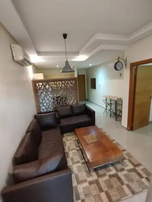 a living room with a leather couch and a table at Cozy 1-BR with Large Terrace in Casablanca