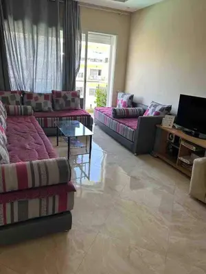 a large living room with couches and a television at Beautiful apartment with pool & beach nearby in Bouznika
