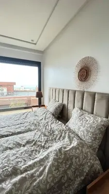 a bedroom with a large bed with a large window at Beachfront Villa in Dar Bouazza in Dar Bouazza
