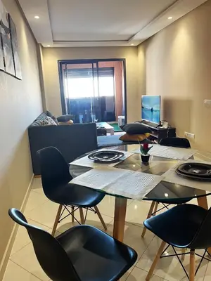 a dining room with chairs and a table and a television at Modern studio near stadium Mohamed V AFCON 2025 in Casablanca