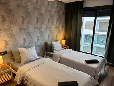 a hotel room with two beds and a window at Elegance & Comfort - Les Princesses District in Casablanca