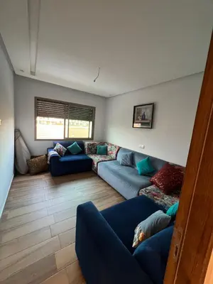 a living room with blue couches in a room at Blue beach Sidi Rahal in Le Polo