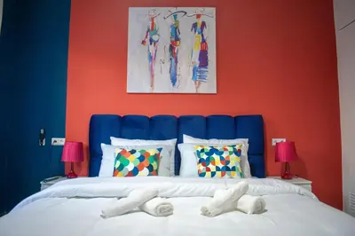 a bedroom with a blue headboard with two white feet on a bed at In the Heart of Casablanca in Casablanca