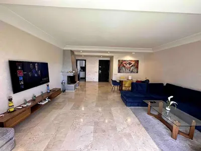 a living room with a blue couch and a table at Appt Centre ville Casablanca Maarif avec Terrasse in Casablanca