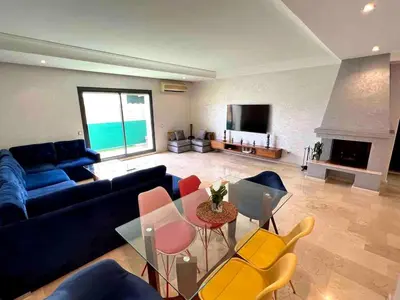 a living room with a couch and a table and chairs at Appt Centre ville Casablanca Maarif avec Terrasse in Casablanca