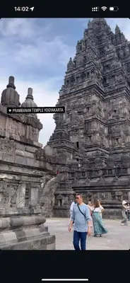 a man and a woman walking in front of a stone building at Emplacement idéal chambre Privée in Rabat