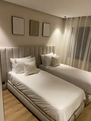 two beds with white sheets and pillows in a room at Luxury apartment in Downtown Casablanca in Casablanca