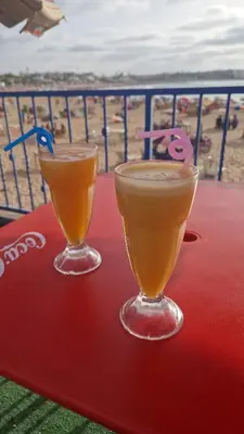 two drinks sitting on top of a table with the beach at Appartement en front de mer à 2 pas des Sablettes in Mohammedia
