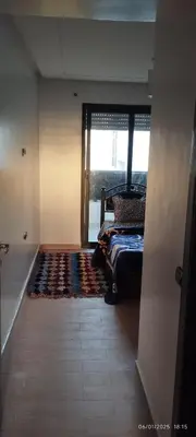 a bedroom with a bed and a window and a rug at المنصورية in Mohammedia