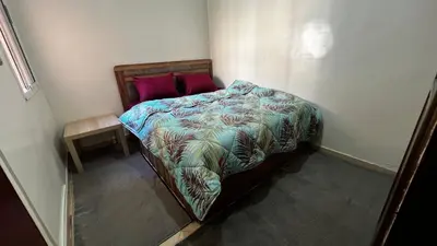 a small bedroom with a bed with a colorful comforter at Apartment busway nearshore in Casablanca