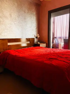 a bedroom with a red bed and a window at Blanca beach in Sidi Rahal