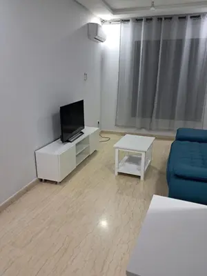 a living room with a blue couch and a tv at Pierro in Maarif