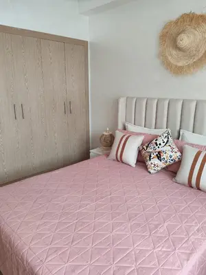 a bedroom with a large pink bed with pillows on it at Beautiful apartment in the heart of Zenata in Aïn Harrouda